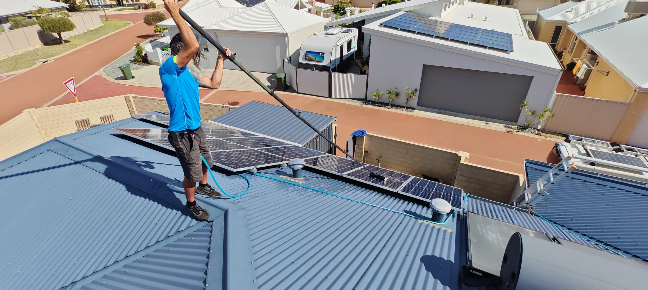 Seaside Suds member cleaning solar panels on roof in mandurah